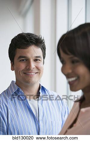 Stock Image - Business people smiling in office. Fotosearch