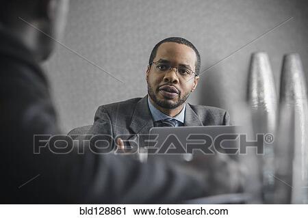 Stock Image - Business people talking in meeting. Fotosearch