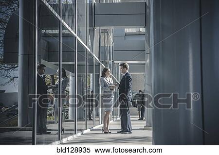 Stock Photography - Business people talking outside office building. Fotosearch