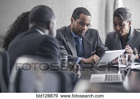 Stock Photo - Business people using digital tablet in meeting. Fotosearch