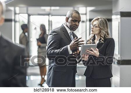 Stock Photo - Business people using digital tablet in office. Fotosearch