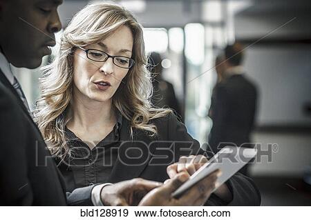 Stock Photo - Business people using digital tablet in office. Fotosearch