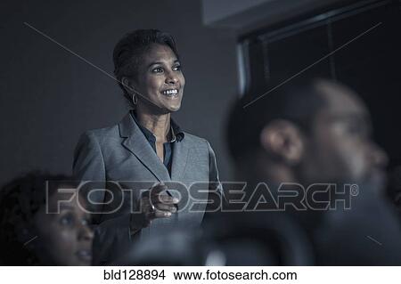 Business people watching audio visual presentation in meeting View Large Photo Image Picture - Business people watching audio visual presentation in meeting. Fotosearch