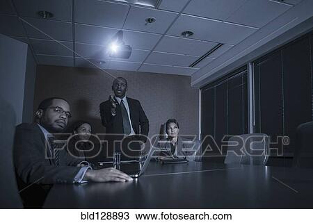 Stock Image - Business people watching presentation in meeting. Fotosearch