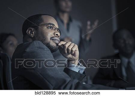Stock Photography - Business people watching projection in meeting. Fotosearch