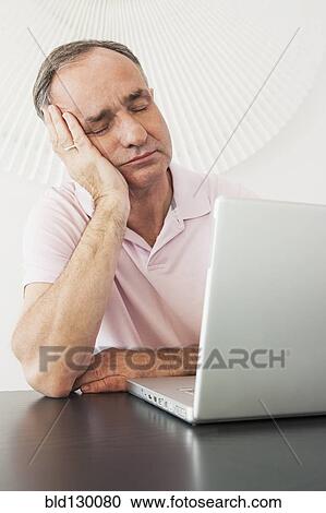 Businessman napping at desk in office View Large Photo Image Stock Image - Businessman napping at desk in office. Fotosearch