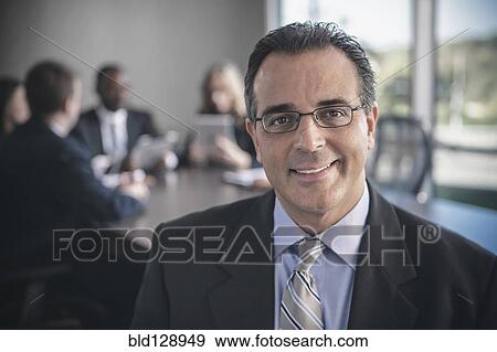 Stock Photo - Businessman smiling in conference room. Fotosearch