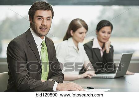 Stock Image - Businessman smiling in meeting. Fotosearch