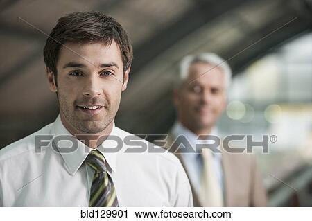 Stock Image - Businessman smiling in office. Fotosearch