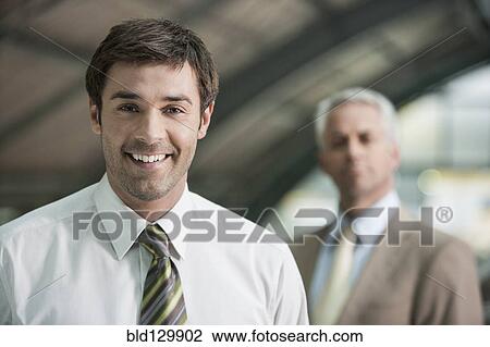 Stock Image - Businessman smiling in office. Fotosearch