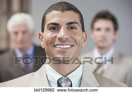 Stock Image - Businessman smiling in office. Fotosearch