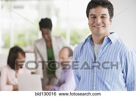 Stock Photograph - Businessman smiling in office. Fotosearch