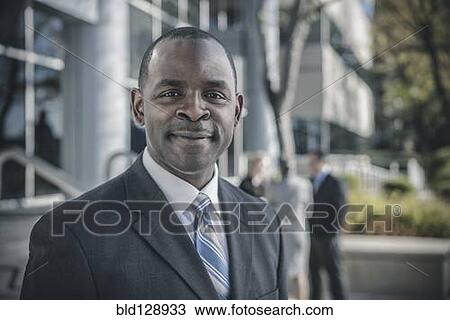 Businessman smiling outdoors View Large Photo Image Stock Image - Businessman smiling outdoors. Fotosearch