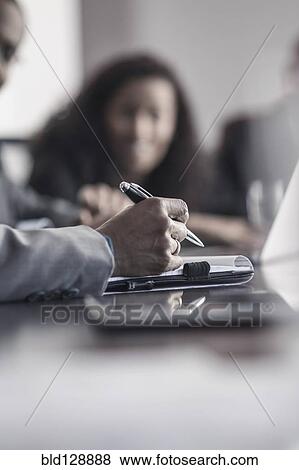 Stock Photo - Businessman taking notes in meeting. Fotosearch