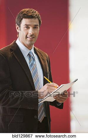 Stock Photo - Businessman taking notes in office. Fotosearch