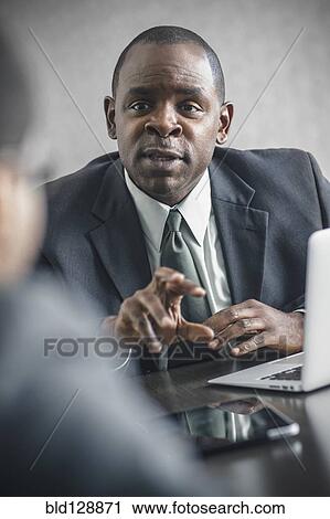 Stock Image - Businessman talking in meeting. Fotosearch