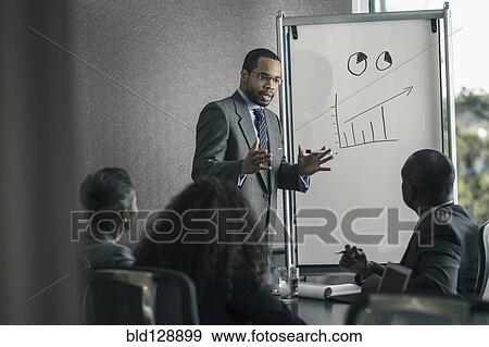 Stock Photo - Businessman talking to colleagues in meeting. Fotosearch