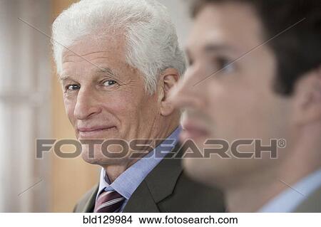 Picture - Businessmen standing in office. Fotosearch