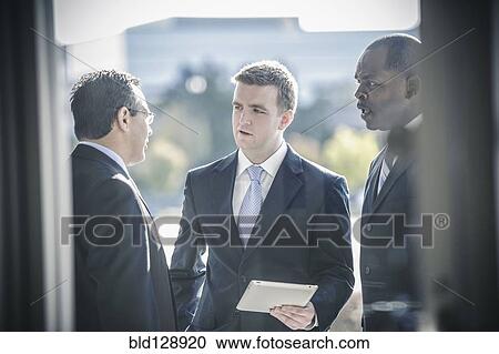 Businessmen using digital tablet outside office View Large Photo Image Stock Image - Businessmen using digital tablet outside office. Fotosearch