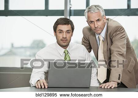 Stock Photography - Businessmen working together in office. Fotosearch