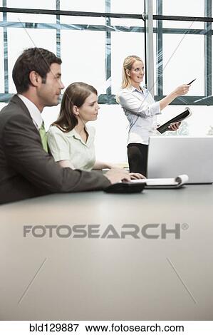 Stock Photo - Businesswoman displaying presentation in meeting. Fotosearch