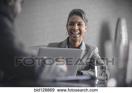 Stock Photo - Businesswoman laughing in meeting. Fotosearch