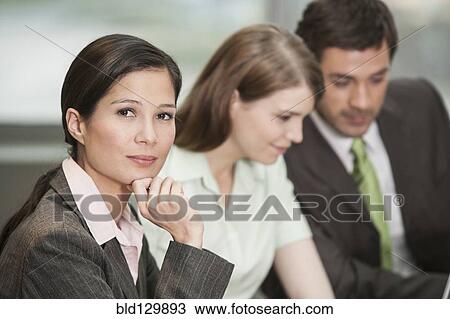 Stock Image - Businesswoman sitting in meeting. Fotosearch