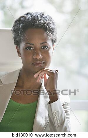 Stock Image - Businesswoman sitting in office. Fotosearch