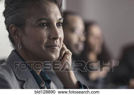 Stock Image - Businesswoman smiling in meeting. Fotosearch