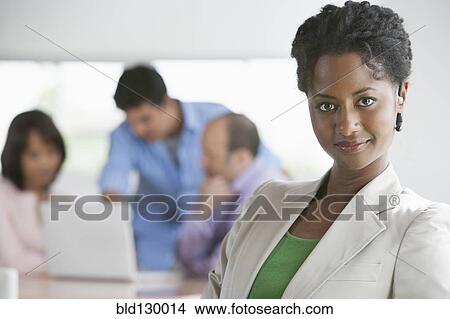 Picture - Businesswoman smiling in office. Fotosearch