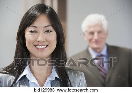Stock Image - Businesswoman smiling in office. Fotosearch