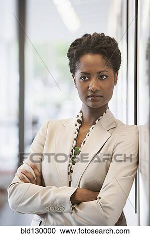 Stock Image - Businesswoman standing in office. Fotosearch