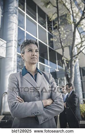 Stock Photography - Businesswoman standing with arms folded outdoors. Fotosearch