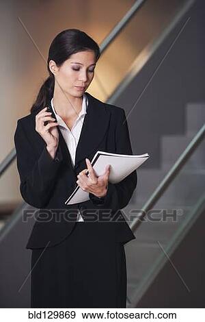 Stock Photo - Businesswoman taking notes in office. Fotosearch