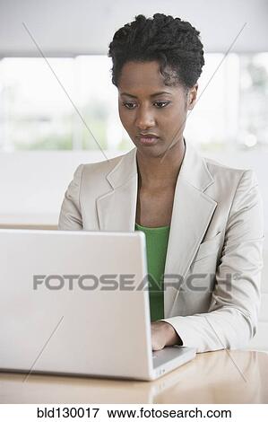 Businesswoman working on laptop at desk View Large Photo Image Stock Photo - Businesswoman working on laptop at desk. Fotosearch