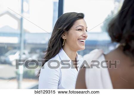 Stock Photography - Businesswomen laughing outdoors. Fotosearch