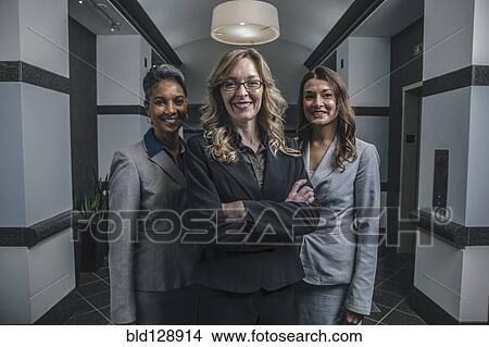 Businesswomen smiling in office corridor View Large Photo Image Picture - Businesswomen smiling in office corridor. Fotosearch