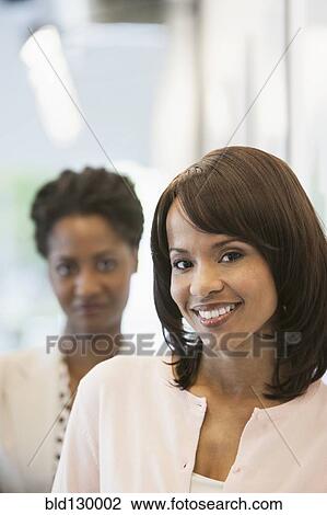 Businesswomen smiling in office View Large Photo Image Stock Image - Businesswomen smiling in office. Fotosearch