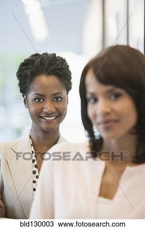 Businesswomen smiling in office View Large Photo Image Stock Image - Businesswomen smiling in office. Fotosearch