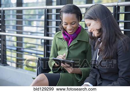 Businesswomen talking on train platform View Large Photo Image Stock Photo - Businesswomen talking on train platform. Fotosearch