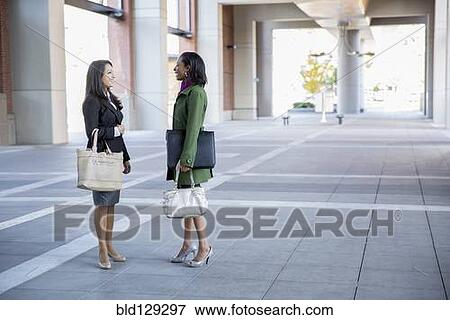 Stock Photo - Businesswomen talking outdoors. Fotosearch