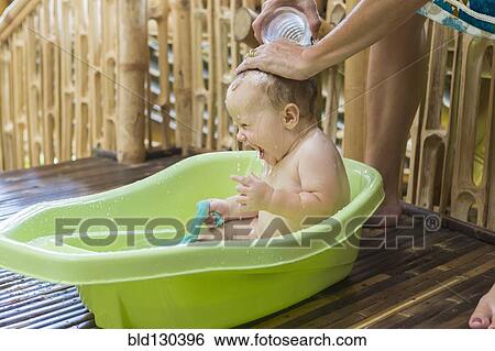 Stock Photograph - Caucasian baby having bath in tub. Fotosearch