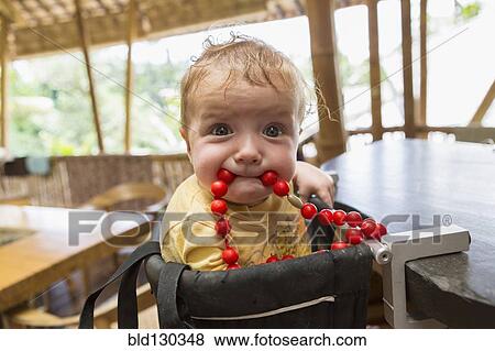 Caucasian baby playing with beads in high chair View Large Photo Image Stock Photo - Caucasian baby playing with beads in high chair. Fotosearch