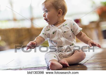 Caucasian baby sitting on floor View Large Photo Image Stock Photo - Caucasian baby sitting on floor. Fotosearch