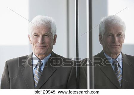 Caucasian businessman leaning on window View Large Photo Image Stock Photography - Caucasian businessman leaning on window. Fotosearch