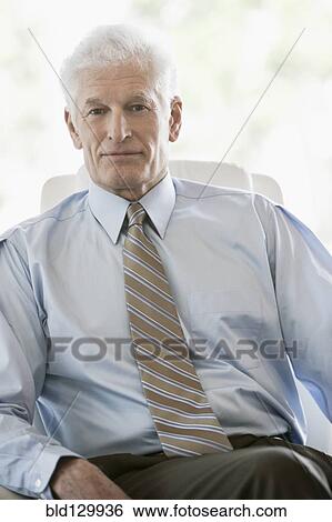 Stock Photograph - Caucasian businessman sitting in office. Fotosearch