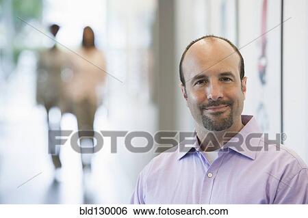 Caucasian businessman smiling in office View Large Photo Image Stock Photograph - Caucasian businessman smiling in office. Fotosearch