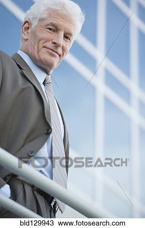 Stock Image - Caucasian businessman standing on balcony. Fotosearch