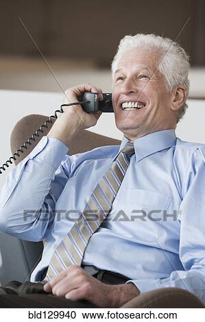 Caucasian businessman talking on telephone View Large Photo Image Stock Image - Caucasian businessman talking on telephone. Fotosearch