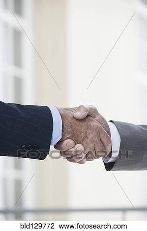Stock Image - Caucasian businessmen shaking hands. Fotosearch